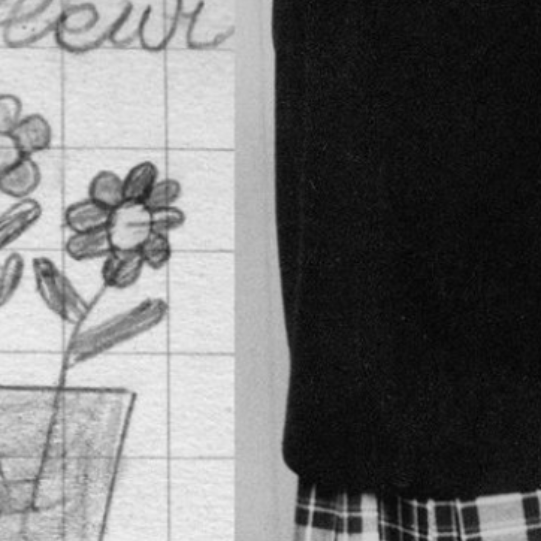 Split image on the left is graph paper with a childrens drawing of a flower and handwritten lettering. On the right is a child in school uniform, a jumper and tartan skirt.